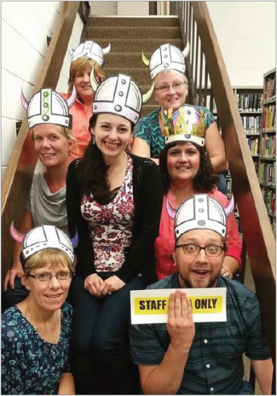 Justin Hoenke (holding sign) with his staff at the Benson Memorial Library