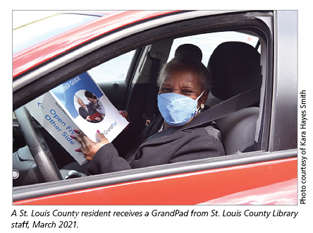 A St. Louis County resident receives a GrandPad from St. Louis County Library staff, March 2021.