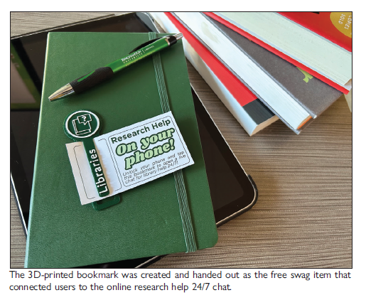 Bookmark clipped to a notecard sits on top of a notebook and tablet alongside a stack of books. Text on the notecard reads: Research Help on your phone! Unlock your phone and tap this bookmark to open a live chat for library help 24/7.