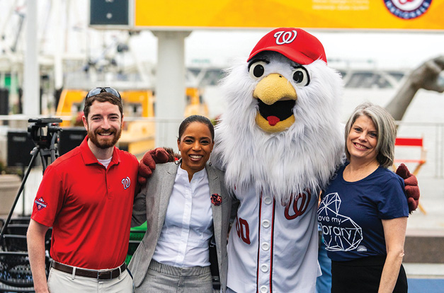 Sports highlight (L to R): Washington Nationals director of community relations Alex Robbins, Prince George’s County Executive Angela D. Alsobrooks, team mascot Screech, and PGCMLS CEO Roberta Phillips pose at the 2021 Summer @ Your Library Kickoff at National Harbor in Oxon Hill, Maryland.