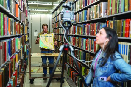 Krystal Ruiz monitors the equipment while recording a video with map librarian Peter Hauge at Los Angeles Public Library.