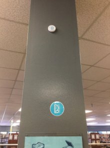 This iBeacon hardware is placed high up to prevent tampering. The BluuBeam logo sticker is placed closer to eye level to inform visitors that a message is available nearby.