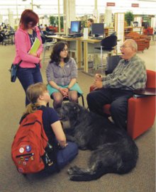 A group of students enjoys hearing stories about the Irish Wolfhound breed.